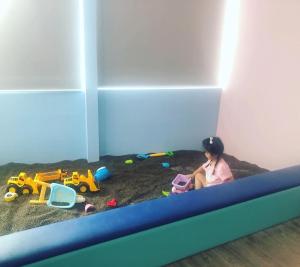 a little girl sitting in a bunk bed with toys at Hotel Wow Penang in George Town