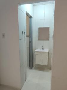 a white bathroom with a sink and a mirror at Motel Hotel Le Premier in Venâncio Aires