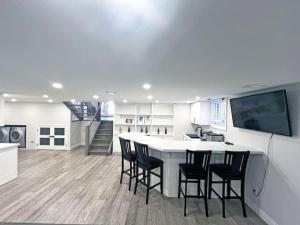 a kitchen with a kitchen island with chairs and a tv at Luxe Home Near Limeridge - Sleeps 11 - Pool in Hamilton