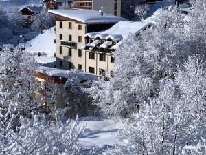 a building with snow covered trees in front of it at Les Balcons de St So Appartement A in Saint-Sorlin-dʼArves +4 photos