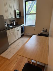 a kitchen with a wooden table and a counter top at Chic Times Square 1BR Entire Apt - Private Kitchen & Bath - Hosts 4 in New York +6 photos