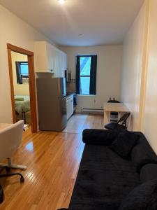 a living room with a couch and a kitchen at Chic Times Square 1BR Entire Apt - Private Kitchen & Bath - Hosts 4 in New York