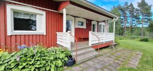 a red house with stairs and a window and flowers at Härköniemen mökki in Leppävirta