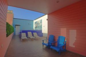 two blue chairs and a table on a patio at Casa Barco Hotel Boutique in Isla Mujeres
