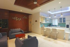a kitchen and living room with chairs and a counter at Casa Barco Hotel Boutique in Isla Mujeres
