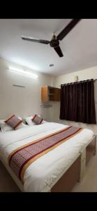 a large bed in a room with a ceiling fan at Vp residency in Bangalore