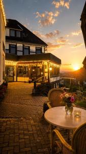 a patio with a table and a building with lights at WELLNESS Hotel UHLENBERG in Bad Münstereifel