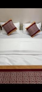 a white bed with two pillows on top of it at Vp residency in Bangalore +1 photo