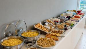 a buffet with many different types of food on a table at Promenade Fusion Itaguaí in Itaguaí