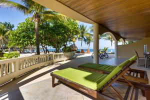 a porch with a hammock and chairs on the beach at Beachfront 2BR Villa with Pool & Spacious Layout in Placencia