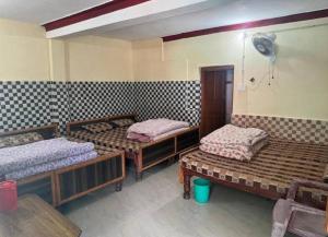 a room with three bunk beds and a fan at Hotel Sunil Lodge in Gaurikund