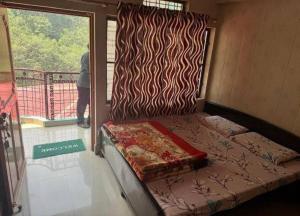 a small bed in a room with a window at Hotel Sunil Lodge in Gaurikund