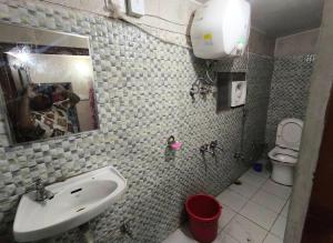 a bathroom with a sink and a mirror and a toilet at Hotel Sunil Lodge in Gaurikund