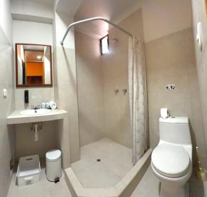 a bathroom with a shower and a toilet and a sink at Pisac Inca Guest House in Pisac