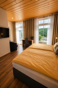 a bedroom with a large bed and a large window at WELLNESS Hotel UHLENBERG in Bad Münstereifel