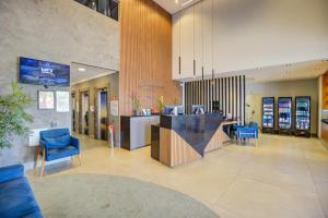 a lobby with blue chairs and a counter in a building at Transamerica Executive Sorocaba in Sorocaba +69 photos