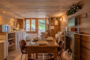 a kitchen and dining room with a table and chairs at Les Évouettes Châtel village in Châtel