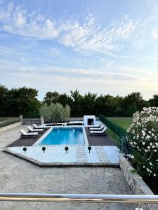 a swimming pool with lounge chairs at Villa Vuletic in Kula Atlagić