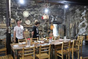 two people standing in a restaurant with a table at Raul Lushnu Darbaz in Mestia