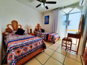 a bedroom with two beds and a ceiling fan at Dpto Exclusive Ixtapa in Ixtapa +10 photos