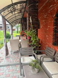 a patio with chairs and a table with flowers at Колиска Карпат in Slavske