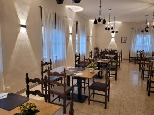 a dining room with tables and chairs and windows at Hotel Cantaleone in San Michele allʼAdige