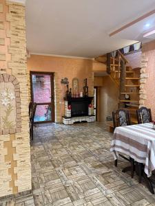 a living room with a table and a fireplace at Колиска Карпат in Slavske
