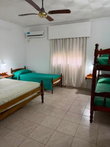 a bedroom with two beds and a ceiling fan at Hosteria Prince in Chajarí