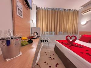 a hotel room with a bed and a table with a red blanket at Igaras Hotel - Centro de Otacílio Costa, 49km de Lages in Otacílio Costa