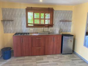 a kitchen with wooden cabinets and a sink and a window at Casa Tolosa Tayrona, Los Cocos in La Poza