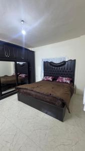 a bedroom with a large bed and a mirror at مطل محنا الجبلي in Ajloun