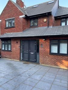 a brick house with black doors and a driveway at Double Room Private Bathroom Parking South Croydon in Addington