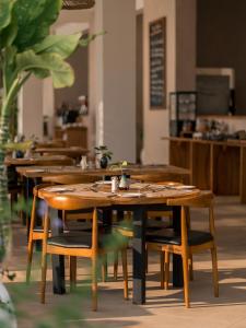 a row of wooden tables and chairs in a restaurant at Kaskazi Hotel Zanzibar in Jambiani +113 photos