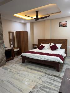 a bedroom with a bed with a ceiling fan at Hotel Omkara View Palace in Godarpura