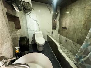 a bathroom with a white toilet and a sink at Suites de Luxe en Hotel in Cuetzalán del Progreso