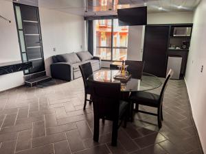 a living room with a table and chairs and a couch at Suites de Luxe en Hotel in Cuetzalán del Progreso