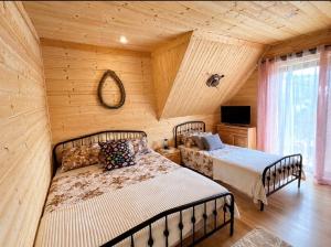 a bedroom with two beds in a log cabin at Góralska Chatka jacuzzi in Kościelisko