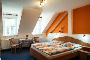 a bedroom with a bed and a table and chairs at Pension Gábi in Františkovy Lázně