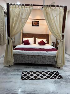 a bedroom with a bed with curtains and a rug at Hotel Omkara View Palace in Godarpura
