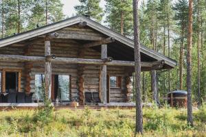 a log cabin in the middle of a forest at Napapiirin Järvilomat in Rovaniemi