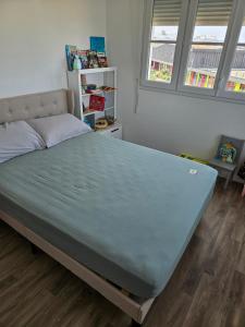 a bed in a room with a large mattress at 3 pièces proche Disney in Serris