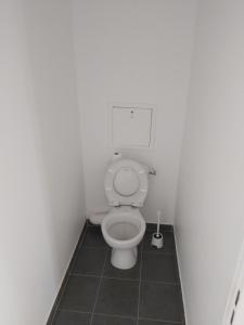 a bathroom with a toilet in a white room at 3 pièces proche Disney in Serris