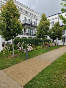 a large white building with a garden in front of it at 3 pièces proche Disney in Serris