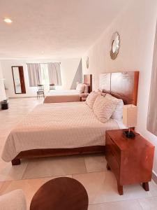 a bedroom with two beds and a table with a lamp at Pedernal Hotel in San Miguel de Allende