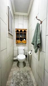 a bathroom with a toilet and a green towel at Nestled Peace in Klerksdorp
