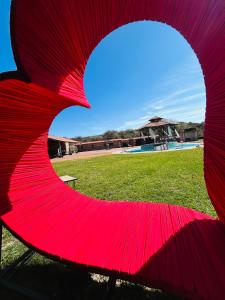 a red umbrella sitting in a park with a field at Pedernal Hotel in San Miguel de Allende