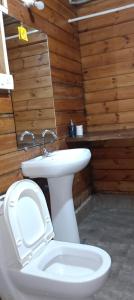a bathroom with a white toilet and a sink at Hotel Inn morjim in Morjim
