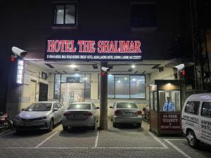 a parking lot with cars parked in front of a building at Hotel The Shalimar in Lahore
