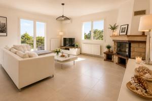 a living room with a white couch and a fireplace at Haut de Villa Bianca - Spacious - Quiet in Saint-Raphaël