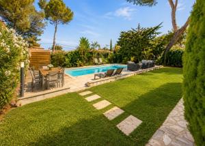 a backyard with a pool and a table and chairs at Haut de Villa Bianca - Spacious - Quiet in Saint-Raphaël